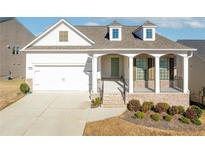 Charming single-story home featuring a welcoming front porch and a two-car garage at 5810 Collier Bridge Ln, Hoschton, GA 30548