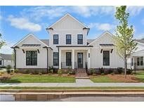 Inviting two-story home boasting a white facade, black window trim, complemented by a well-manicured lawn at 509 Pearl St, Cumming, GA 30040