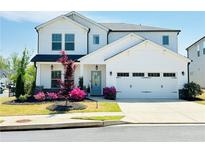 Charming two-story home with a well-maintained lawn, beautiful landscaping, and a two-car garage at 802 Oak Promenade Ln, Canton, GA 30115