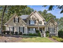 Charming home featuring manicured landscaping, a welcoming porch, and a classic design with a mix of materials and textures at 1400 Lamont Cir, Dacula, GA 30019