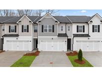 Charming new construction townhome featuring multiple units, brick accents, and manicured landscaping at 345 Sound Cir # 134, Stockbridge, GA 30281