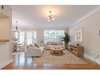 Bright living room with hardwood floors, plush sofas, and large windows at 6980 Roswell Rd # J6, Atlanta, GA 30328