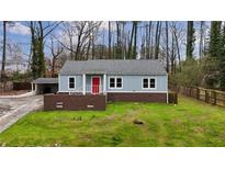 Charming blue home with red door, brick accents, and a well-maintained lawn at 589 Northern Ave, Clarkston, GA 30021