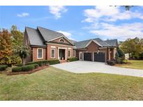 Brick home with a three-car garage and landscaped lawn at 6202 Talmadge Nw Way, Acworth, GA 30101