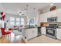 Bright open living area featuring modern kitchen with stainless steel appliances and a cozy seating area near bright windows at 3621 Vinings Slope Se # 1537, Atlanta, GA 30339
