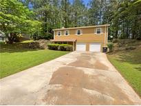 Two-story home featuring a lengthy driveway and an attached two-car garage surrounded by lush trees at 5942 Rock Court #5, Union City, GA 30291