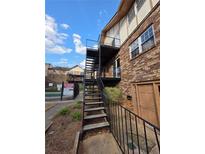 Brick building featuring exterior staircase, access to units, and community pool at 1177 Church St # F, Decatur, GA 30030