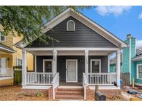 Charming dark gray one-story home with a welcoming front porch, white trim, and brick-lined steps at 400 Bass Sw St, Atlanta, GA 30310