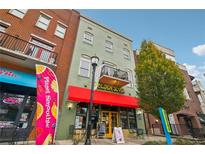 Building exterior featuring a green facade, red awning, and street-level businesses at 320 Town Center Ave # U206B, Suwanee, GA 30024