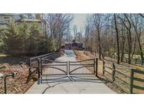 Long driveway leading to a modern home with a gated entrance at 600 Jones Rd, Roswell, GA 30075