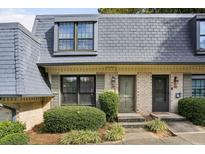Charming townhome featuring a well-maintained yard and classic architectural details at 29 La Rue Nw Pl, Atlanta, GA 30327