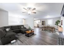 Open-concept living room with gray flooring, modern sectional sofa, and stylish decor at 3950 Yancey Rd, Douglasville, GA 30135