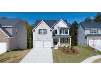 Two-story home with gray brick, two-car garage, and landscaping at 583 Princeton Elm Pl, Lawrenceville, GA 30045