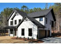 Beautiful two-story home with white siding, black trim, and an attached two-car garage at 3785 Pilgrim Mill Rd, Cumming, GA 30041