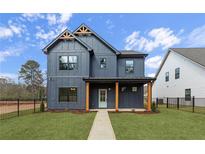 Charming two-story home boasts a modern farmhouse style with a well-manicured lawn and inviting entrance at 42 Puckett Se Rd, Emerson, GA 30137