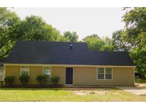Charming single-story home featuring a dark roof, neutral siding, and manicured front yard landscaping at 99 Libby Ln, Jonesboro, GA 30238