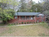 Charming brick home with a cozy front porch and a well-maintained landscaped yard at 5655 Campbellton Sw Rd, Atlanta, GA 30331
