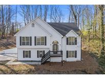 Charming two-story home featuring white siding, black shutters, and a neatly landscaped front yard at 7205 Jonsway, Cumming, GA 30041