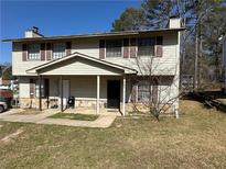 Charming two-story home featuring a covered porch, neutral siding, and well-maintained landscaping at 1185 Oak Villas Nw Ct, Conyers, GA 30012