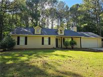 Charming single-story home with a well-manicured lawn and attached two-car garage at 115 Bond Dr, Ellenwood, GA 30294