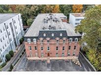 Stately brick building featuring classic architectural details and a spacious parking area, surrounded by mature trees at 3649 Peachtree Ne Rd # 201, Atlanta, GA 30319