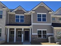 Charming townhome with a brick and beige exterior, featuring large windows and a welcoming front porch at 4841 Walkers Green, Mableton, GA 30126