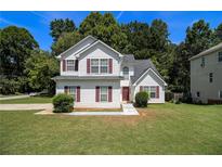 Charming two-story home with white siding and well-manicured lawn, perfect for Gathering living at 4103 Kingship Dr, Ellenwood, GA 30294