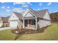 Brick home with craftsman style, 2-car garage, and landscaped yard at 2760 Marie Way, Cumming, GA 30028