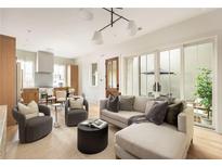 Bright living room featuring stylish seating, modern lighting, and sliding doors to the patio at 1188 Lupo Loop, Chattahoochee Hills, GA 30268