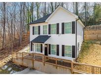 Two-story house with white siding, black shutters, and a wooden deck at 3385 Continental Dr, Cumming, GA 30041