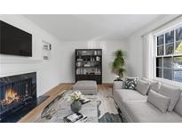 Bright living room with modern furnishings, fireplace, and large window offering natural light at 10 Chaumont Nw Sq, Atlanta, GA 30327