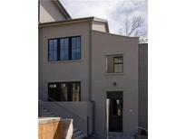 Modern home exterior featuring black-framed windows and a stylish entrance with steps at 10939 Serenbe Ln, Chattahoochee Hills, GA 30268