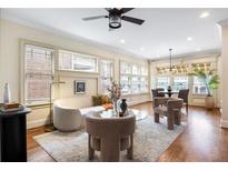 Bright living room featuring hardwood floors, large windows, modern furniture, and a ceiling fan at 653 N Highland Ne Ave # 1, Atlanta, GA 30306