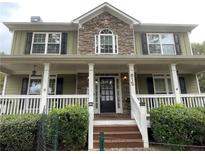 Charming two-story home featuring a stone accent, a welcoming front porch, and lush landscaping at 815 Sylvan Dr, Marietta, GA 30066