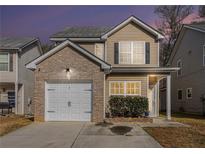 Charming two-story home with brick accents, a one-car garage, and well-maintained landscaping at 6427 Grey Fox Way, Riverdale, GA 30296