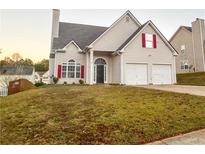 Charming two-story home with a two-car garage, arched entryway, and well-maintained lawn at 137 St Ann Cir, Dallas, GA 30157