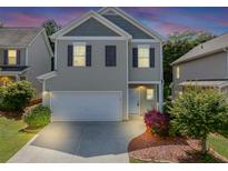 Charming two-story home features a two-car garage, neutral siding and dark shutters at 363 Lobdale Falls Dr, Lawrenceville, GA 30045