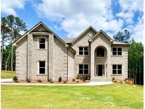 Charming brick home featuring a manicured lawn, traditional architecture, and a welcoming entrance at 5390 Deer Run Dr, Conyers, GA 30094