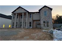 Stately two-story brick home featuring a covered entry with prominent columns and classic architectural details at 157 Shadburn Ferry Rd, Buford, GA 30518