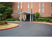 Elegant brick building with a covered entrance and landscaped surroundings, offering a welcoming arrival experience at 3060 Pharr N Ct # 313, Atlanta, GA 30305