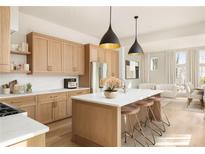 Spacious kitchen features wooden cabinets, quartz countertops, island with seating, and modern pendant lighting at 10931 Serenbe Ln, Chattahoochee Hills, GA 30268