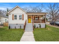 Charming home featuring a bright yellow door, shuttered windows, and a cozy, covered front porch at 1375 Miller Reed Se Ave, Atlanta, GA 30315