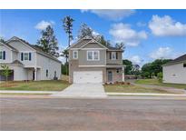 Charming two-story home with a brick and siding facade and a two-car garage at 16 Camellia Dr, Fairburn, GA 30213