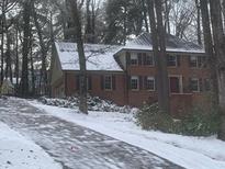 Brick house with snow covered roof and landscaping at 1461 Fox Forest Sw Ter, Lilburn, GA 30047