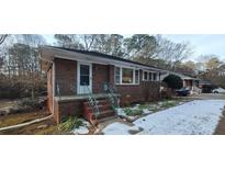 Brick ranch home with steps and small front yard; some snow on the ground at 1181 Rocksprings St, Forest Park, GA 30297