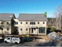 Tan two-story home under construction with dark roofing and a modern design at 1210 Lupo Loop, Chattahoochee Hills, GA 30268