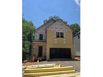 Two-story home featuring siding and an attached garage, set against a backdrop of lush trees on a sunny day at 1664 Crestridge Se Dr, Marietta, GA 30067