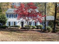 Two-story house with blue shutters, landscaping, and a tree with red leaves at 1111 Valley Ridge Se Ct, Marietta, GA 30067