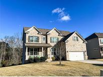 Two-story brick home with a large front yard and attached garage at 7860 Bristol Valley Dr, Cumming, GA 30028