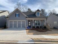 Charming single-story home with gray siding, a two-car garage, and well-manicured landscaping at 207 Hickory Bluffs Pkwy, Canton, GA 30114